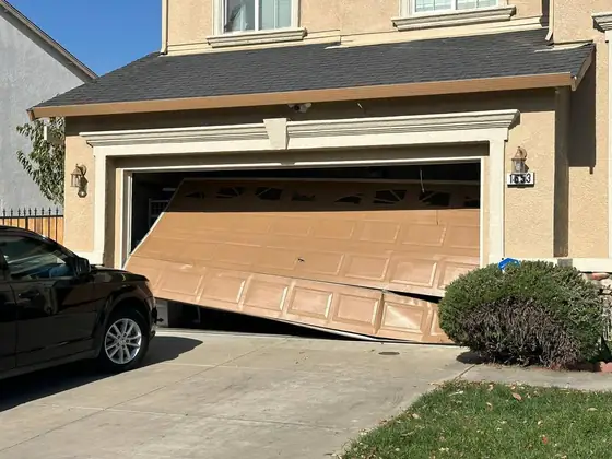 Door off its track and hanging out of the opening